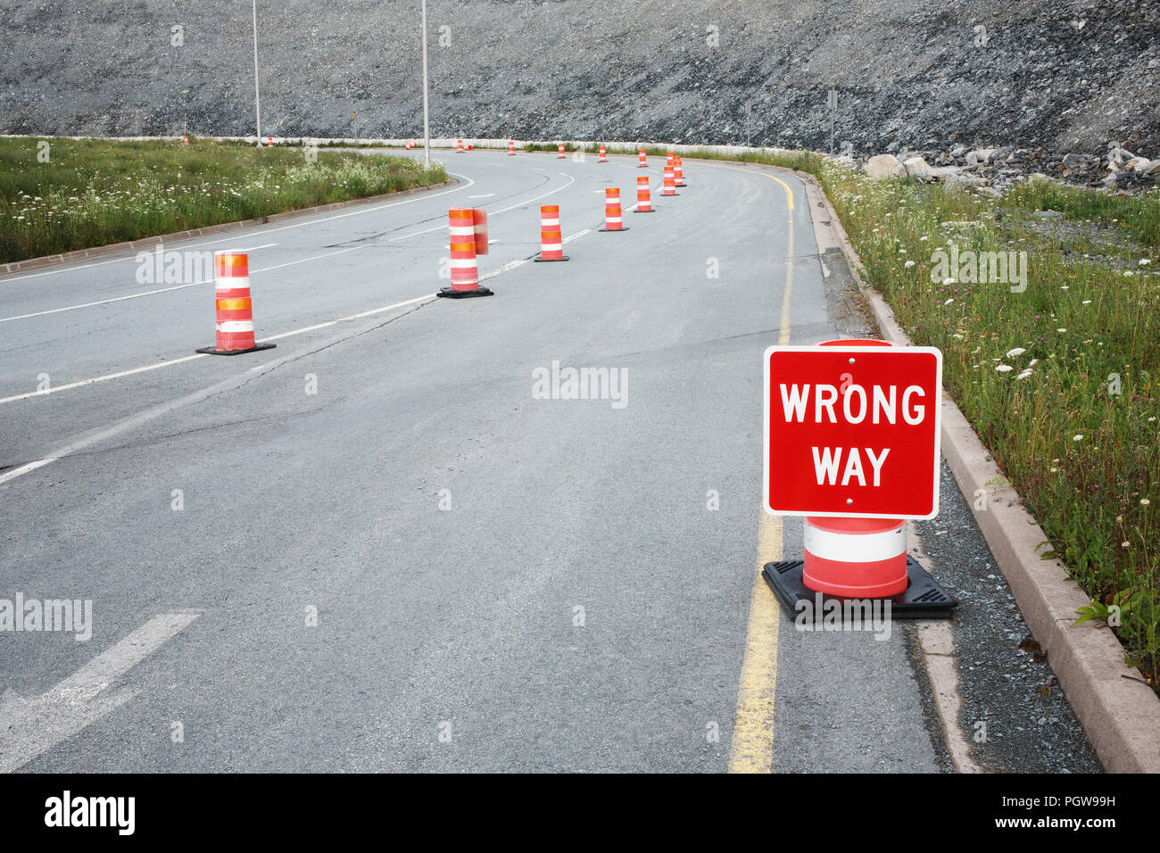 Wrong way traffic sign and safety cones. Stock Photo