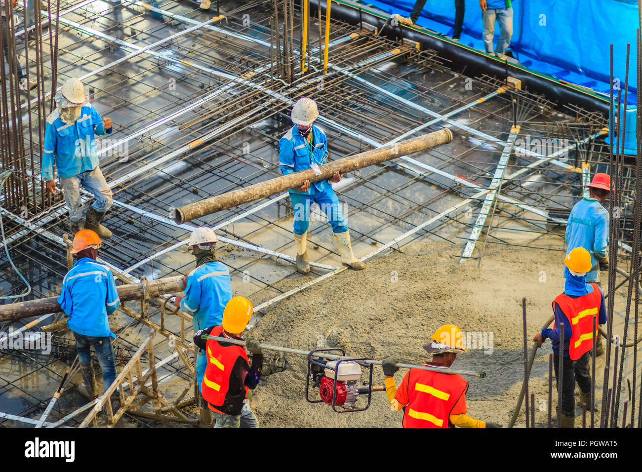 Construction workers are pouring concrete in posttension flooring work