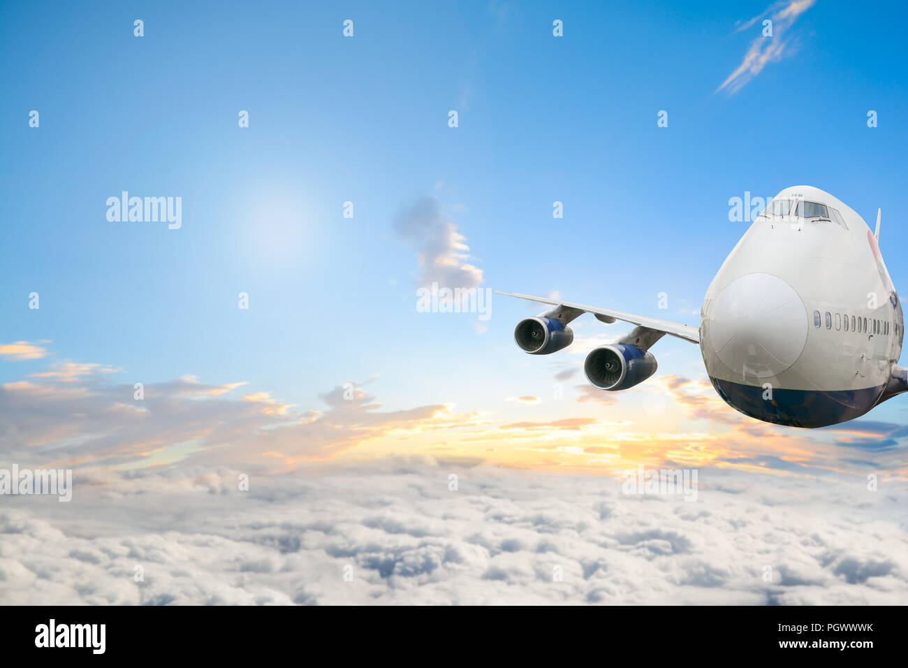 Commercial passenger jet plane flying high above clouds Stock Photo