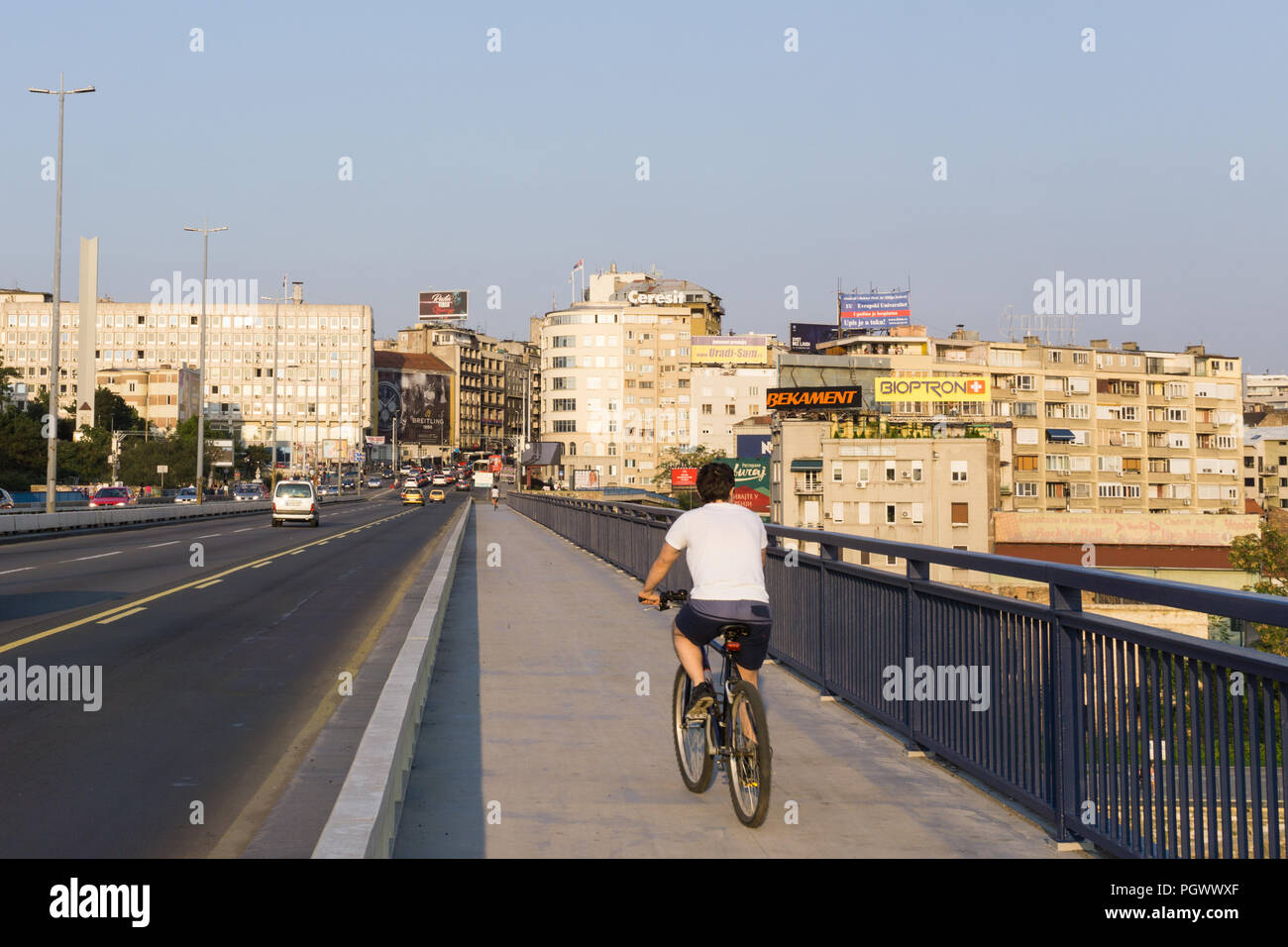 Man cycling across the Branko Bridge, toward the old town of Belgrade, Serbia. Stock Photo