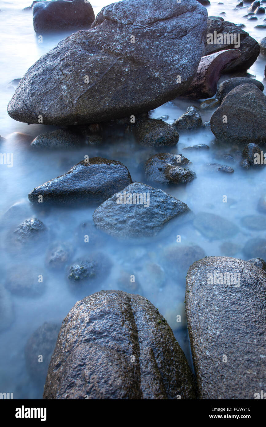 Rocks in sea water, long exposure shoot Stock Photo