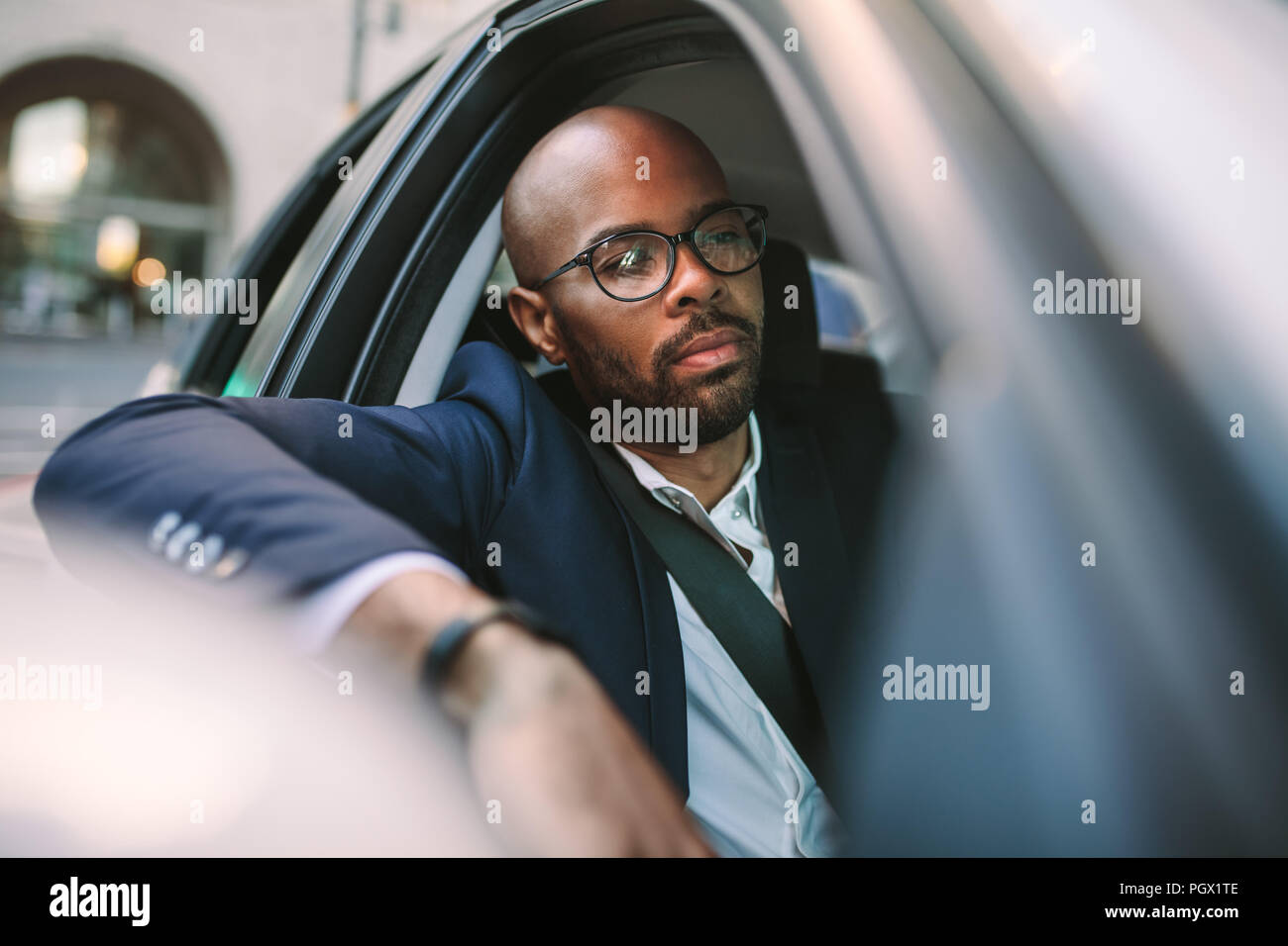 Young man driving a car in city. Businessman going to work in a car. Stock Photo