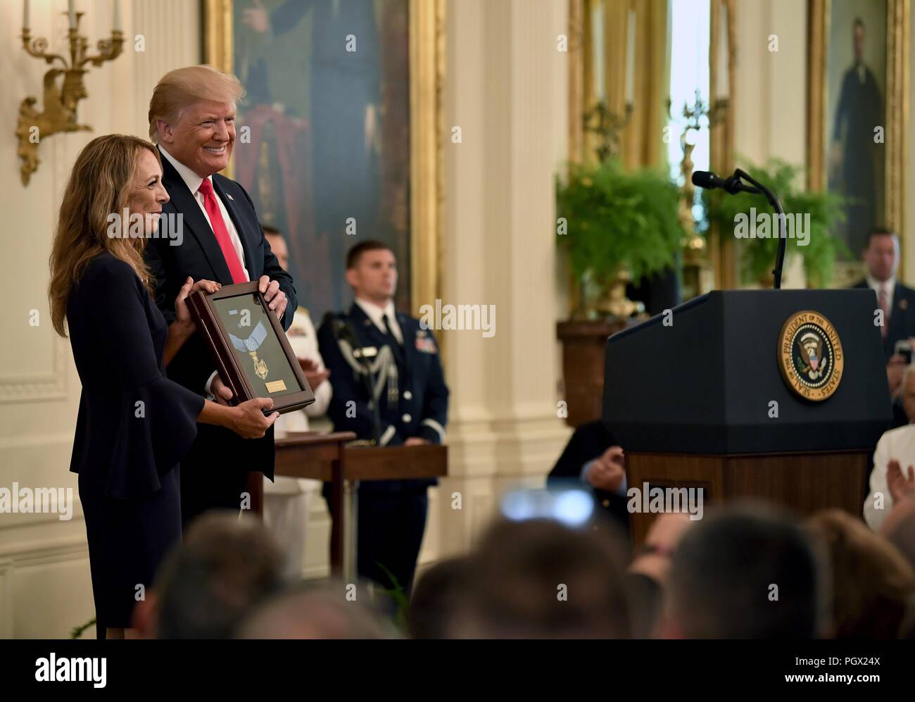 President Donald J. Trump presenting the Medal of Honor to Valerie Nessel, the spouse of U.S. Air Force Tech, August 22, 2018. Sgt. John Chapman, at the Medal of Honor ceremony, White House, Washington, D.C. Image courtesy Wayne Clark / Secretary of the Air Force Public Affairs. () Stock Photo
