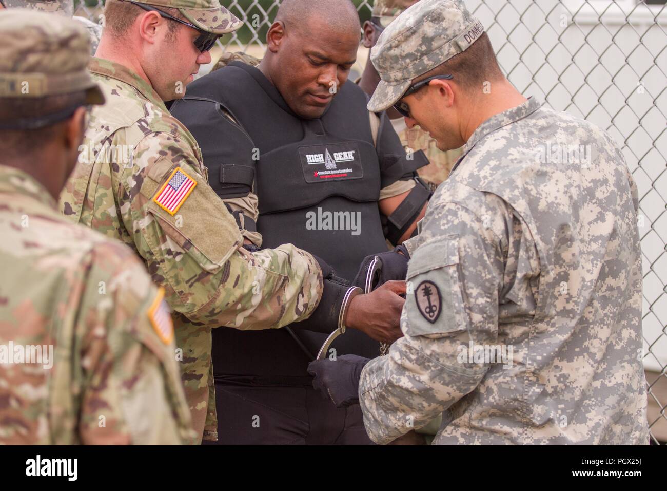 U.S. Army Military Police Soldiers securing a detainee with handcuffs, role-played by Sgt. 1st Class Marcus Brown, during Combat Support Training Exercise (CSTX) at Fort McCoy, Wisconsin, August 20, 2018. Image courtesy Spc. Cody Hein / 86th Training Division. () Stock Photo
