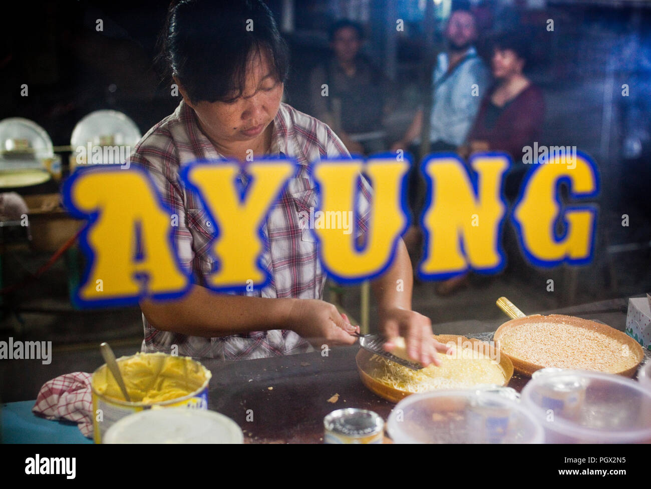A street food vendor prepares chocolate and cheese martabaks (Indonesian pancakes) on Bangka Island. Stock Photo