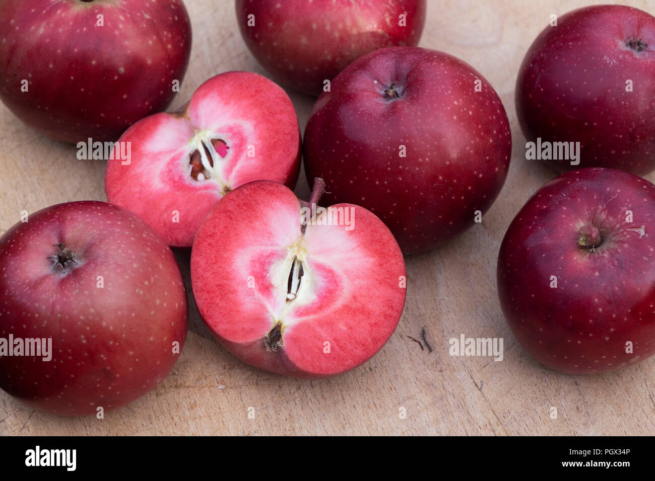 Malus domestica ‘Tickled pink’ / Baya marisa. Harvested Apple ‘Tickled pink’.  Cut in half to show the red flesh Stock Photo
