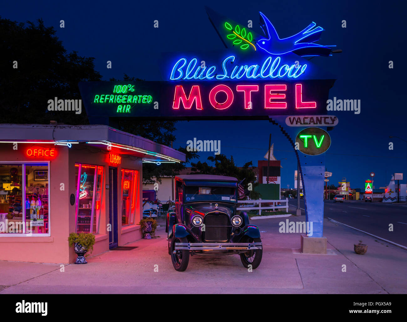 Route 66 New Mexico, Blue Swallow Motel neon sign at night and 1929 Model A Ford truck in Tucumcari, NM. Stock Photo