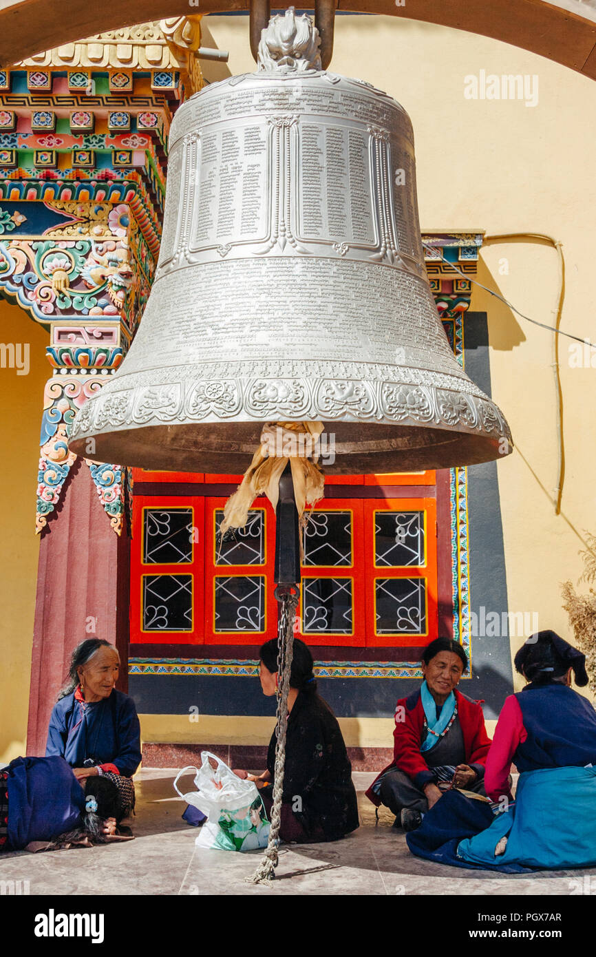 Bodhnath , Kathmandu, Bagmati, Nepal : Tibetan pilgrim women rest under the big bell at the Buddhist monastery in Boudhanath. Stock Photo