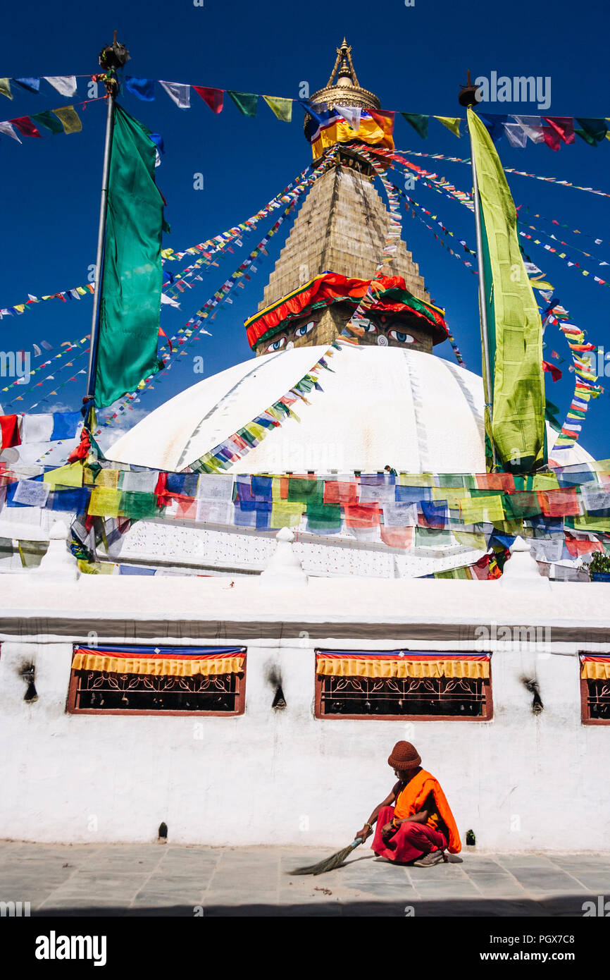 Bodhnath , Kathmandu, Bagmati, Nepal A Buddhist monk in maroon robes sweep the floor around