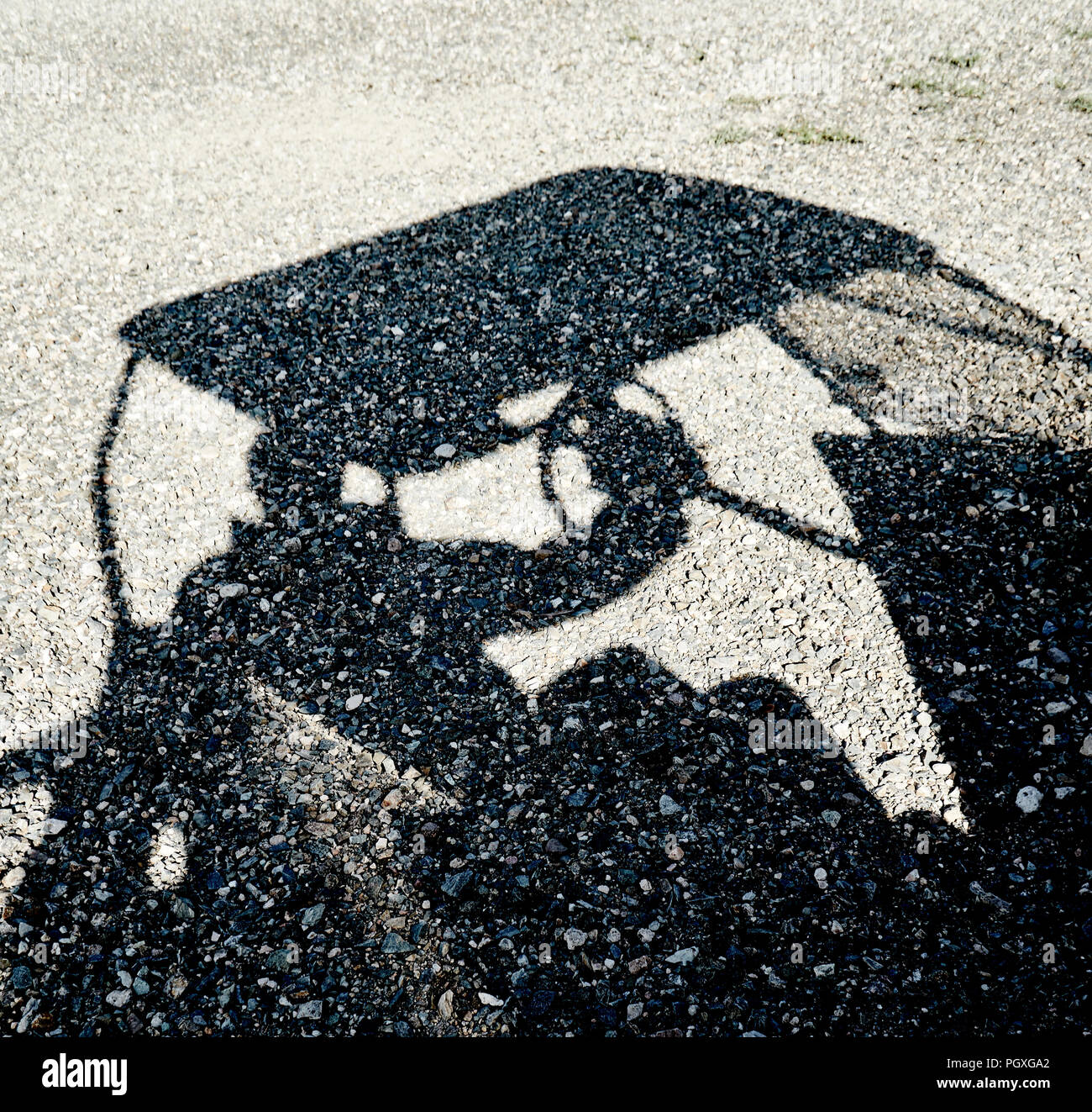 Shadow of a person driving a golf cart  reflected on a gravel ground Stock Photo