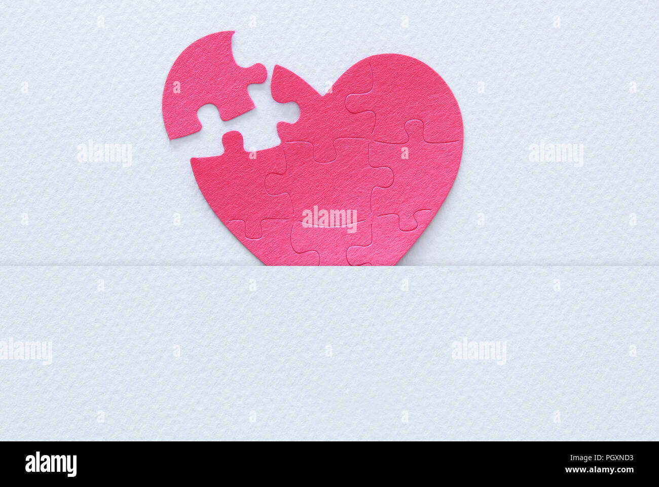 Top view image of paper pink heart puzzle with missing piece over white ...
