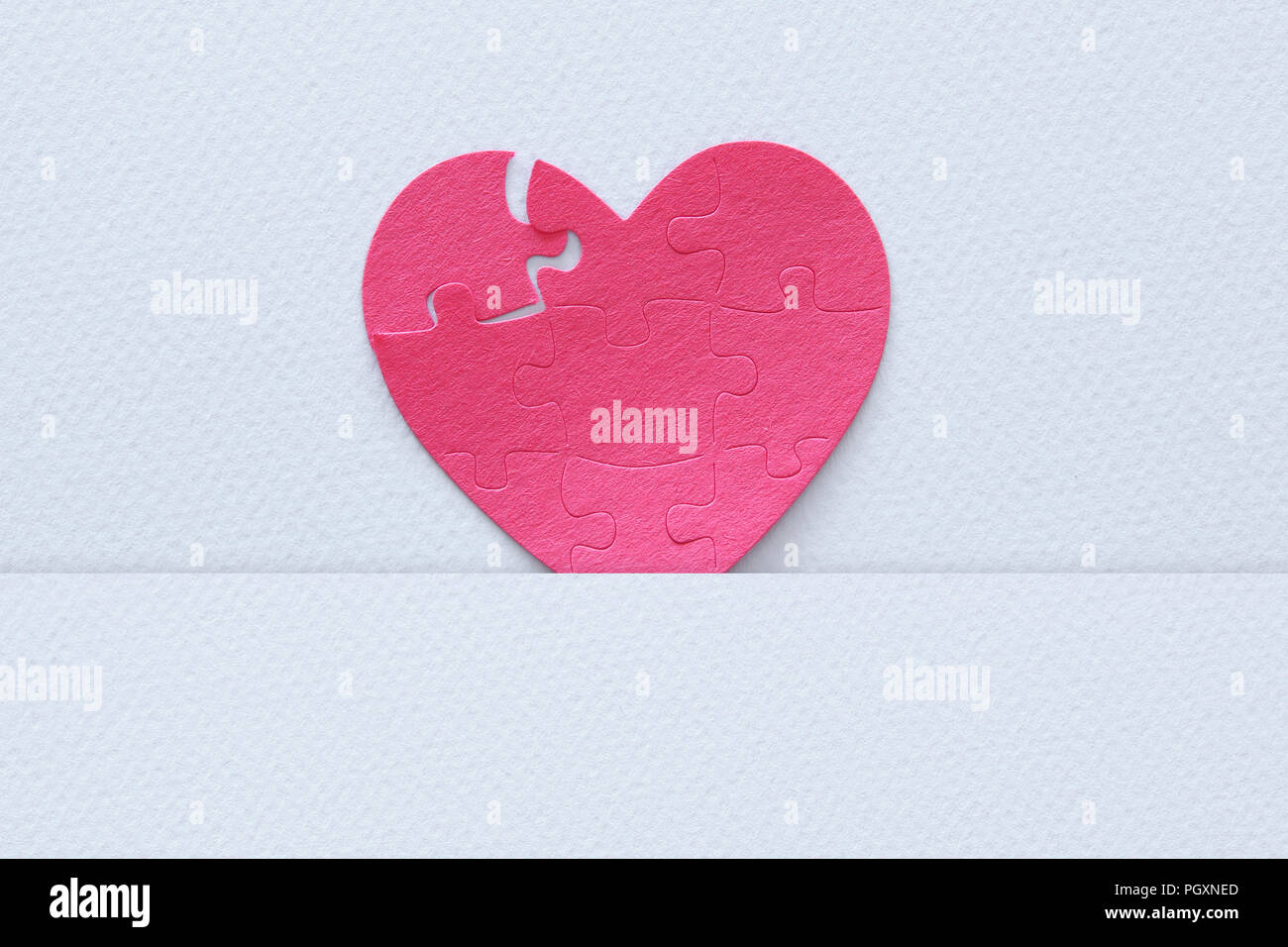 Top view image of paper pink heart puzzle with missing piece over white ...