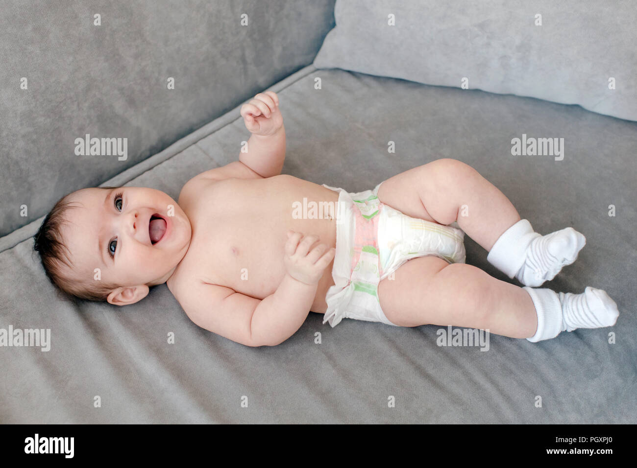 Cheerful adorable baby on sofa Stock Photo