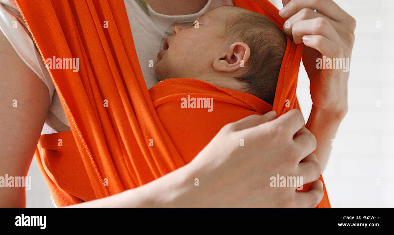 Woman carrying newborn in baby cling Stock Photo