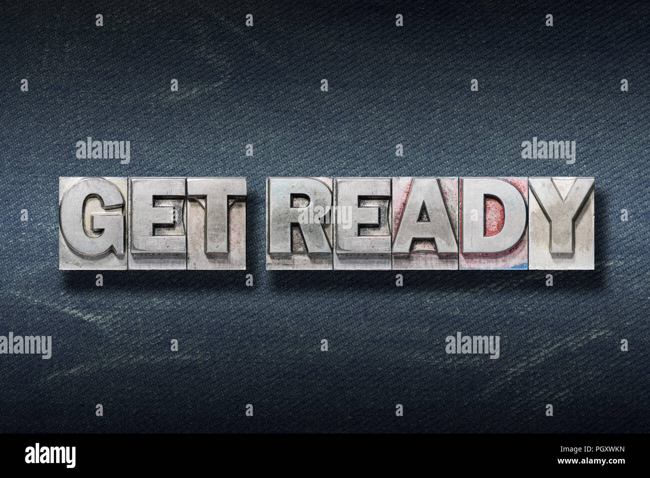 get ready phrase made from metallic letterpress on dark jeans background Stock Photo