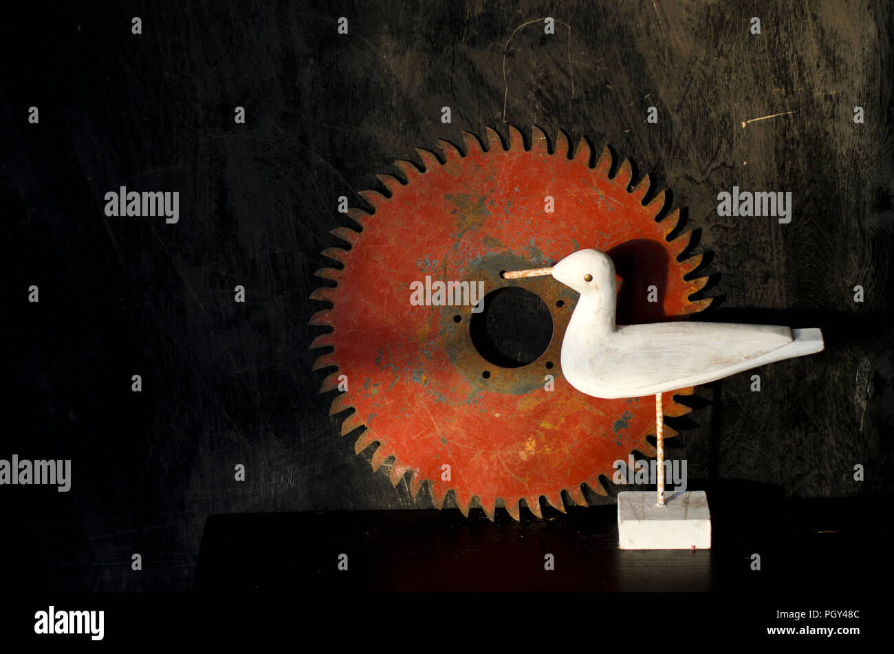 Nature morte still life with wooden white bird and old circuliar saw disc Stock Photo