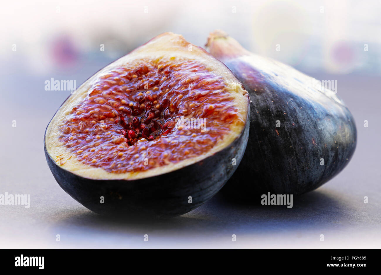 Figs whole and sliced on gray background Stock Photo