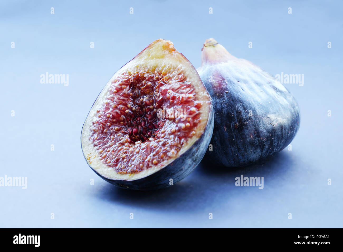 Figs whole and sliced on gray background Stock Photo