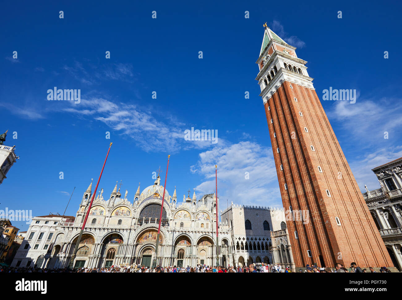 San Marco basilica facade, bell tower and square with crowd of people and tourists, blue sky in a sunny summer day in Venice, Italy Stock Photo