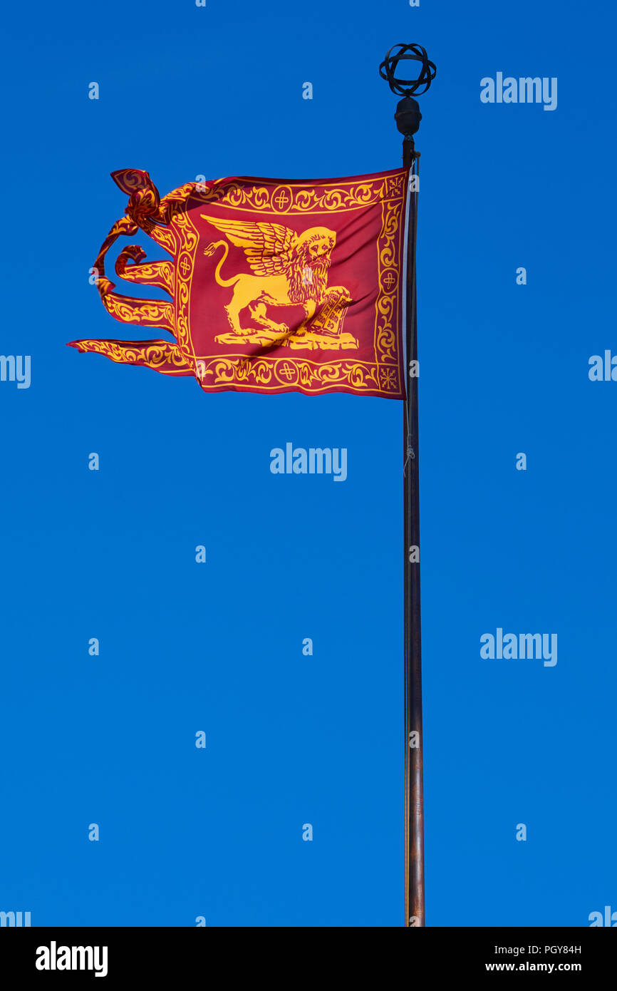 Venice, traditional Serenissima flag with Saint Mark lion, blue sky in a sunny day Stock Photo