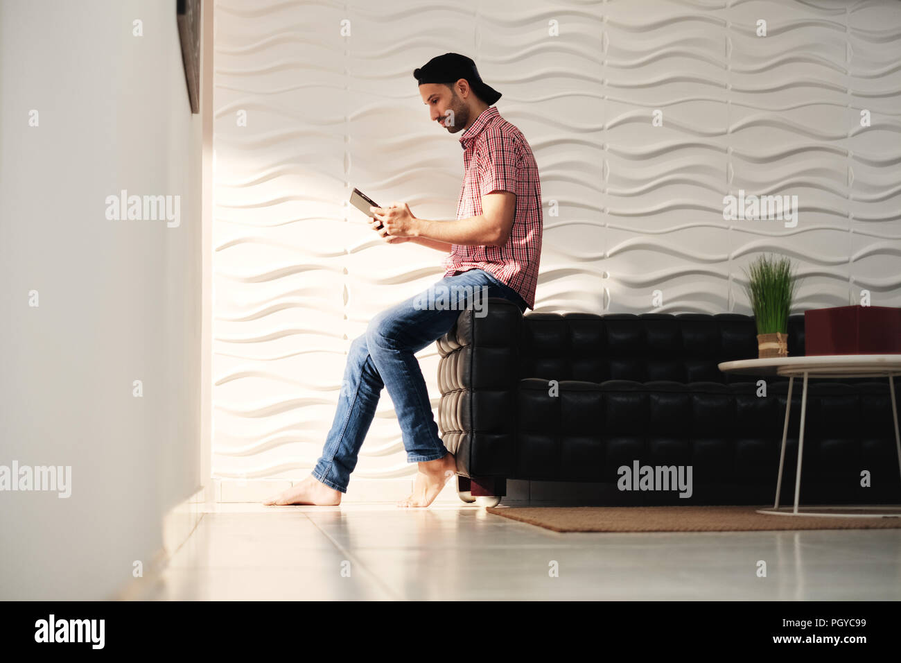 Young Hispanic Man Watching Movie On Tablet Computer Stock Photo