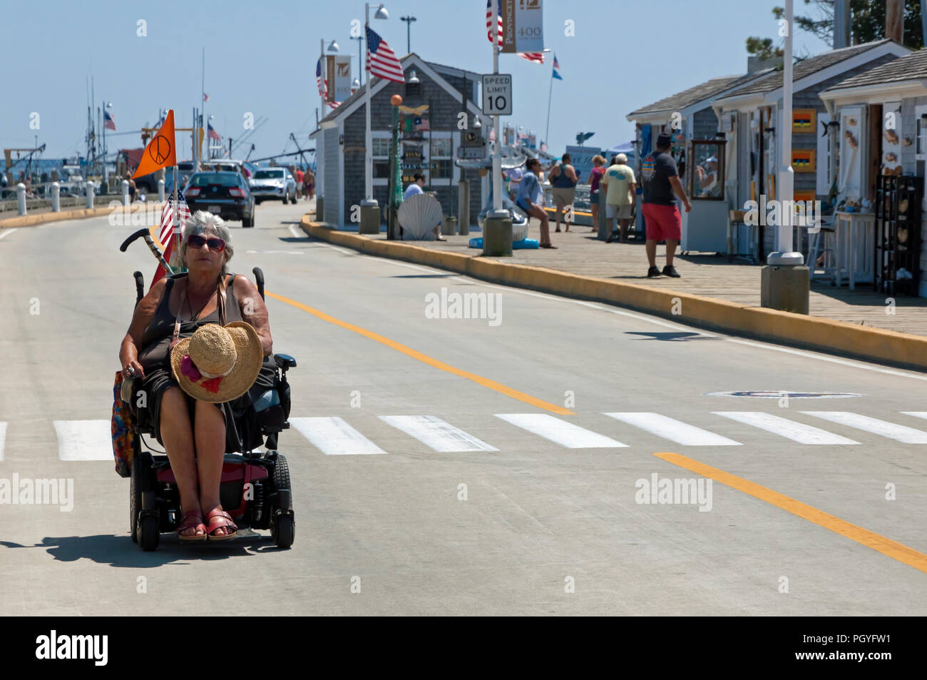 Handicapped female senior citizen using electric wheelchair on vacation. Stock Photo