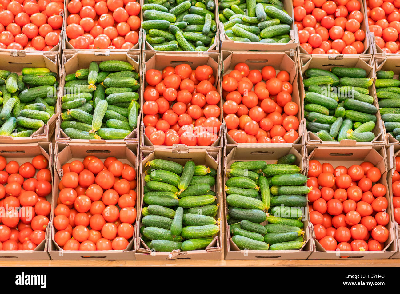 Tomatoes and cucumbers in boxes in the store. Beautiful background of vegetables. Healthy eating. Food for Vegetarians. Healthy lifestyle. Stock Photo