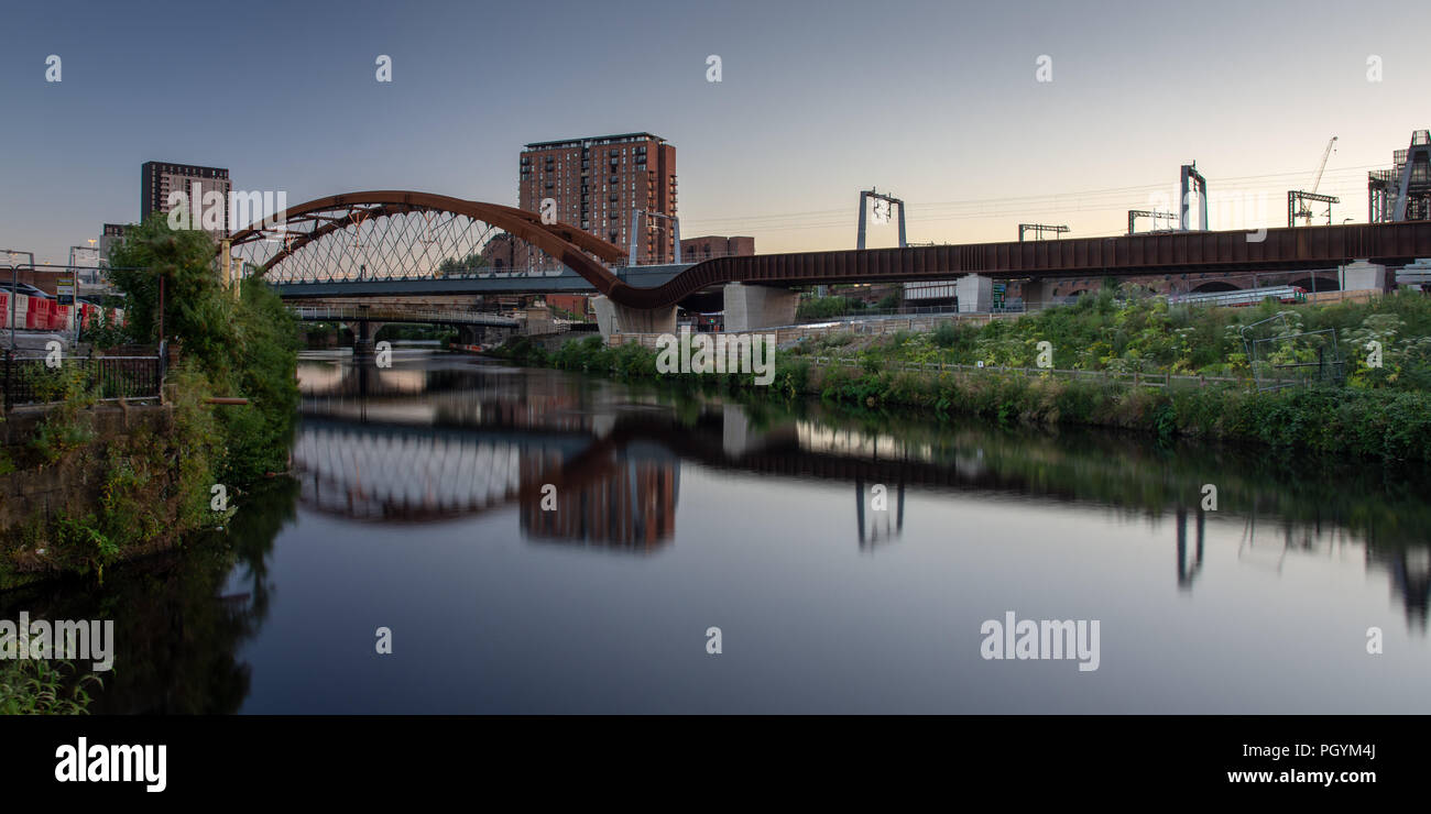 The River Irwell flows between Manchester and Salford under the newly constructed Ordsall Chord railway, part of the 'Northern Powerhouse' investment  Stock Photo