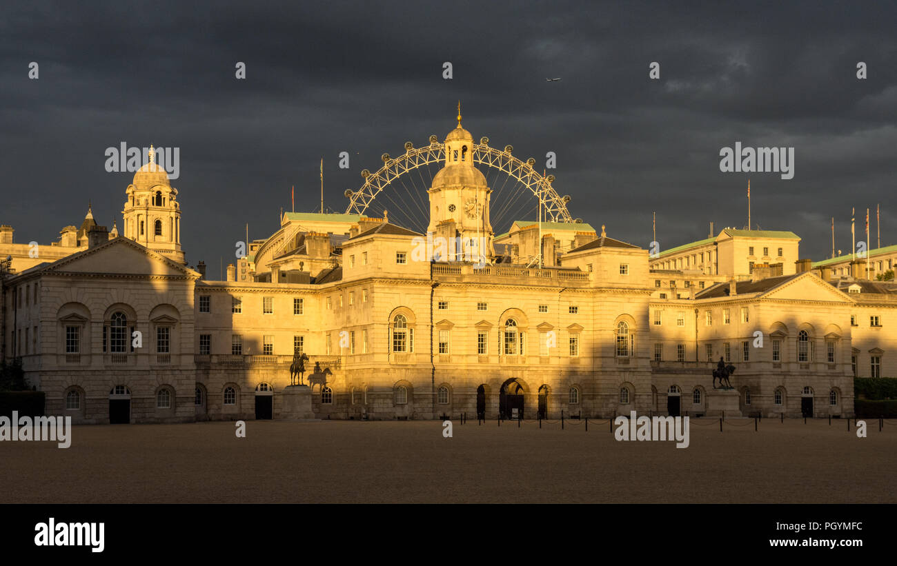 London, England - August 5, 2015: Evening sunlight falls on the government buildings of Whitehall and the London Eye over Horse Guards parade ground a Stock Photo