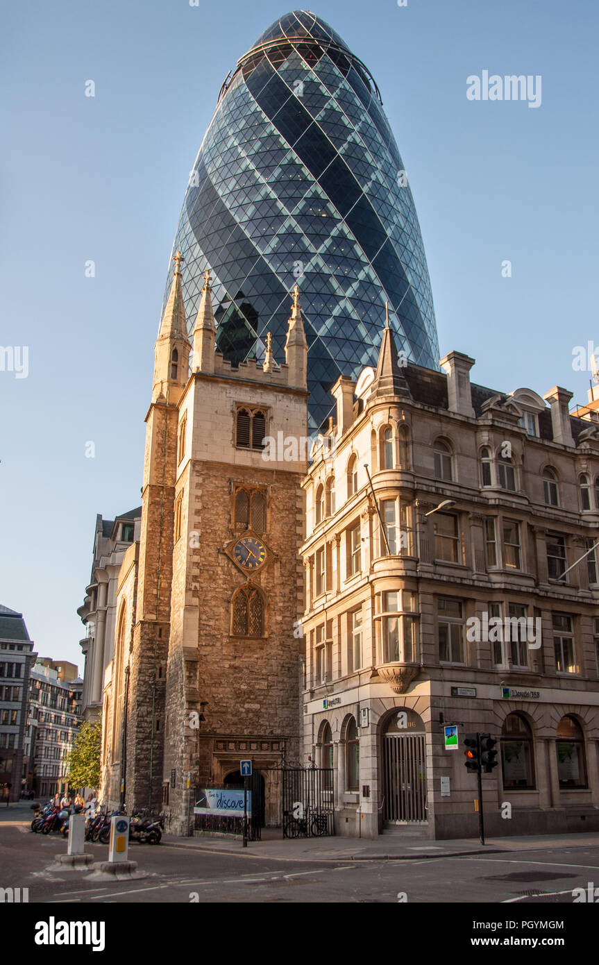 London, England, UK - July 3, 2009: Old and new are juxtaposed in the city of London with St Andrew Undershaft, a traditional parish church, standing  Stock Photo