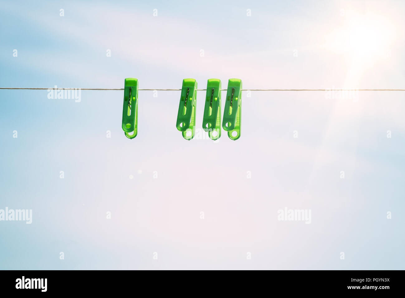 Clothespins on a rope against sky Stock Photo