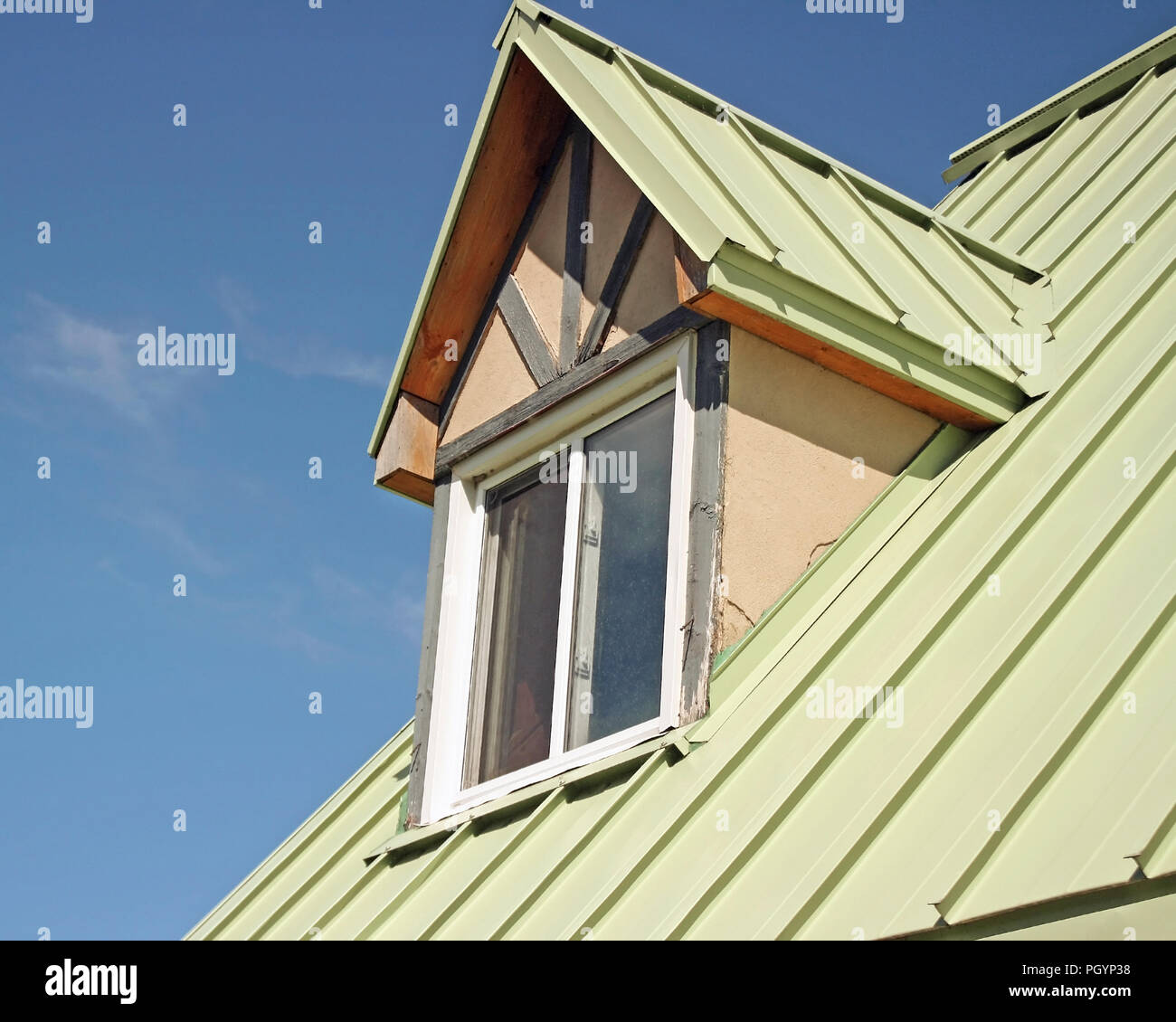 Dormer, also known as a rooftop window with sage green aluminum siding Stock Photo