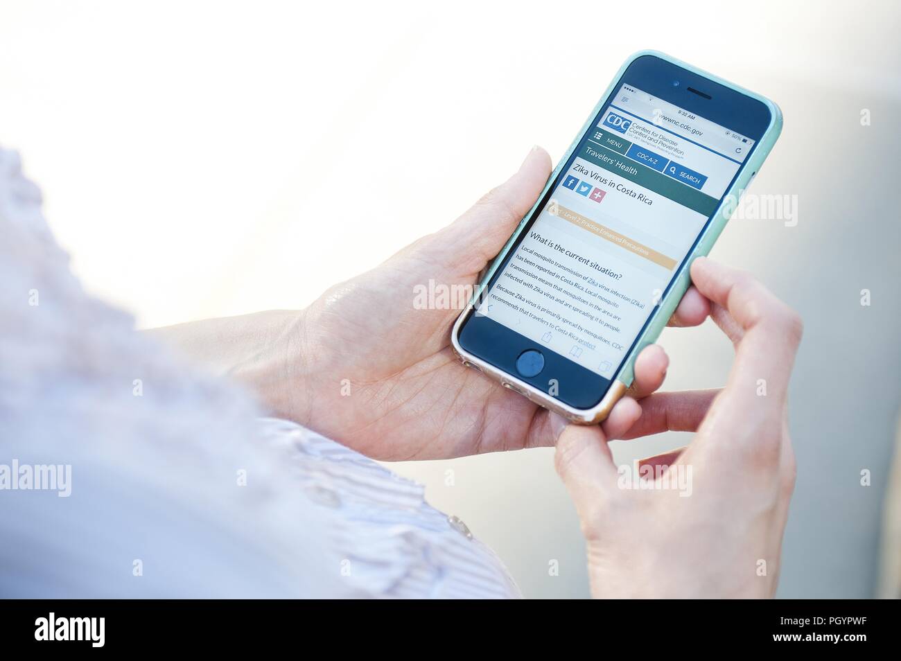 Woman reading about Zika virus in Costa Rica on her smartphone, 2016. Image courtesy Centers for Disease Control (CDC) / National Center for Emerging and Zoonotic Infectious Diseases (NCEZID). () Stock Photo