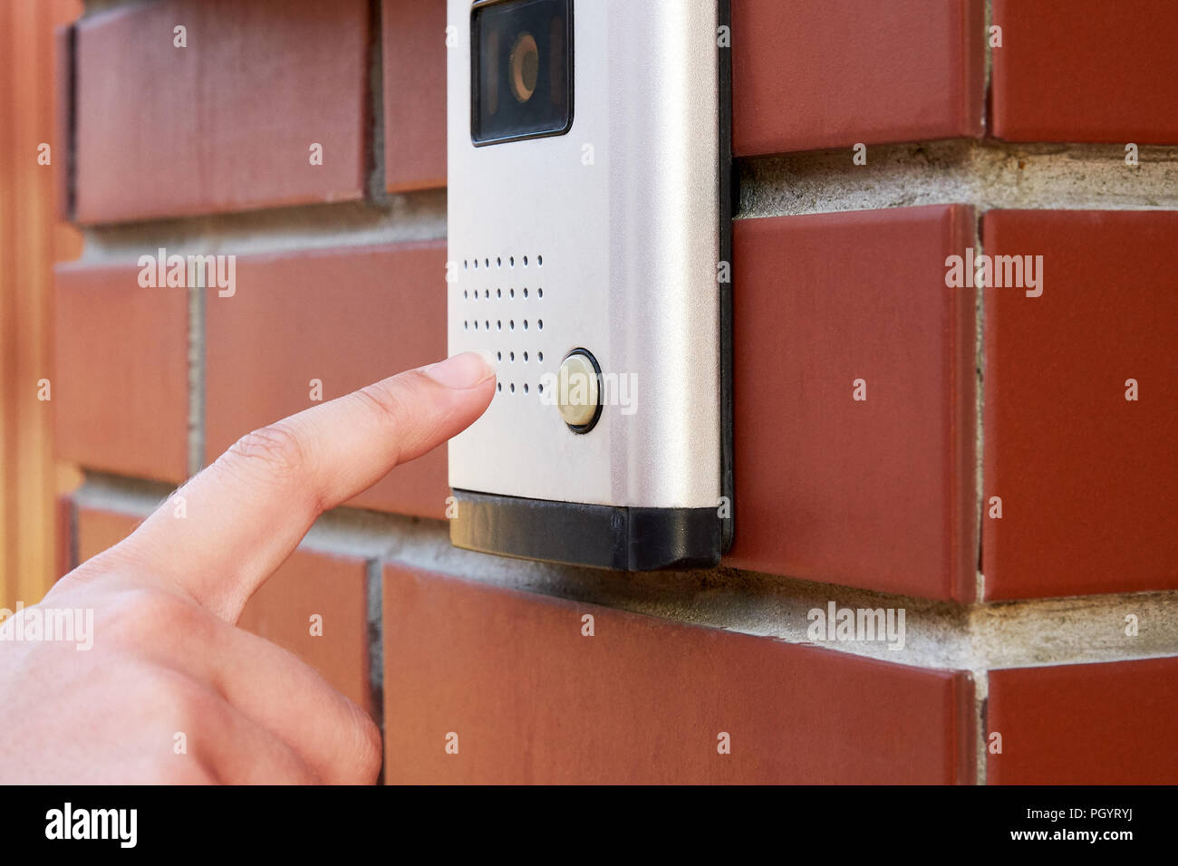 The female hand presses a button doorbell with camera and intercom Stock Photo