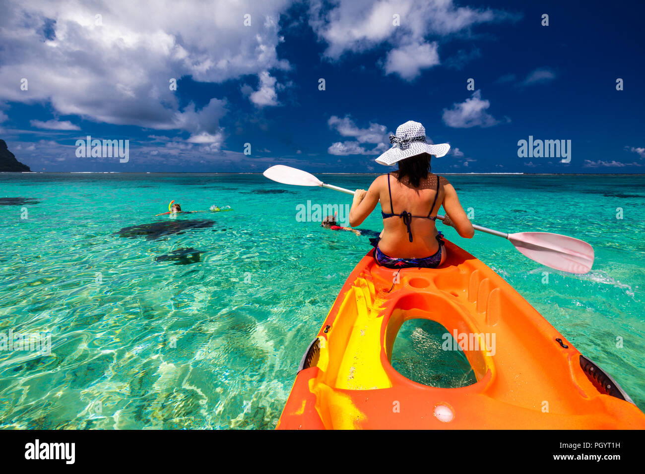 Woman in white hat Kayaking in the lagoon of tropical Samoa Islands Stock Photo