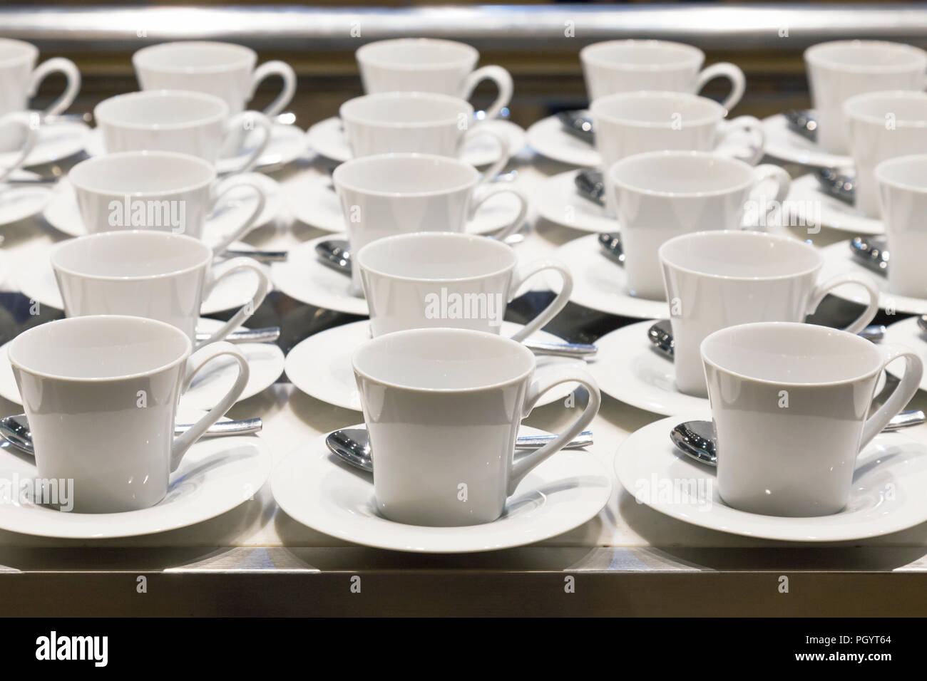 row of coffee and tea ceramic white cup preparing to serve on the business conference in front of the meeting room at the hotel. Stock Photo