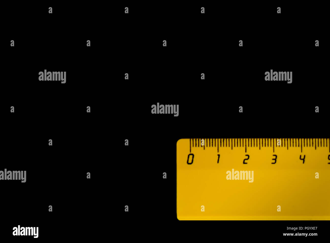 yellow ruler on a black background 5 centimeters Stock Photo