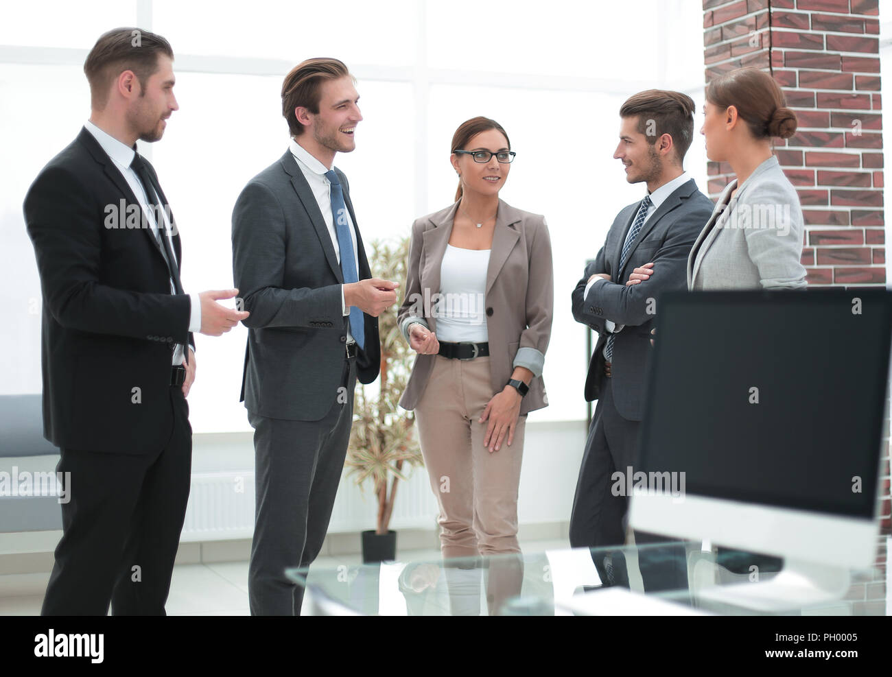 business team talking standing in the office Stock Photo - Alamy