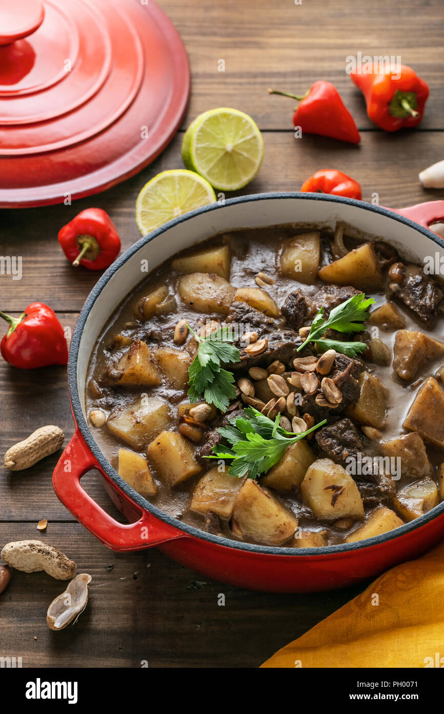 Thai Beef Massaman Curry served in big red pot, top view Stock Photo