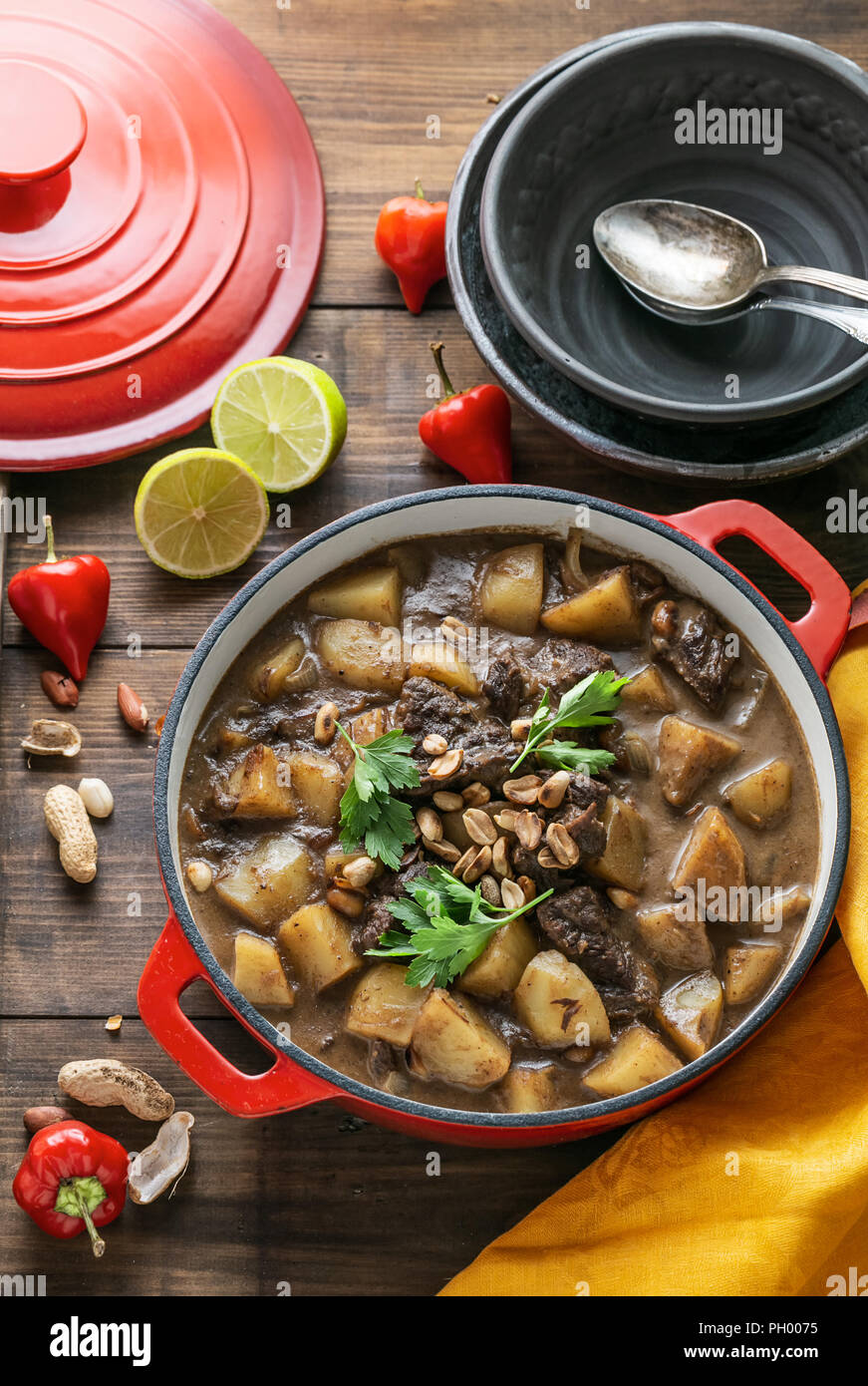 Thai Beef Massaman Curry served in big red pot, top view Stock Photo