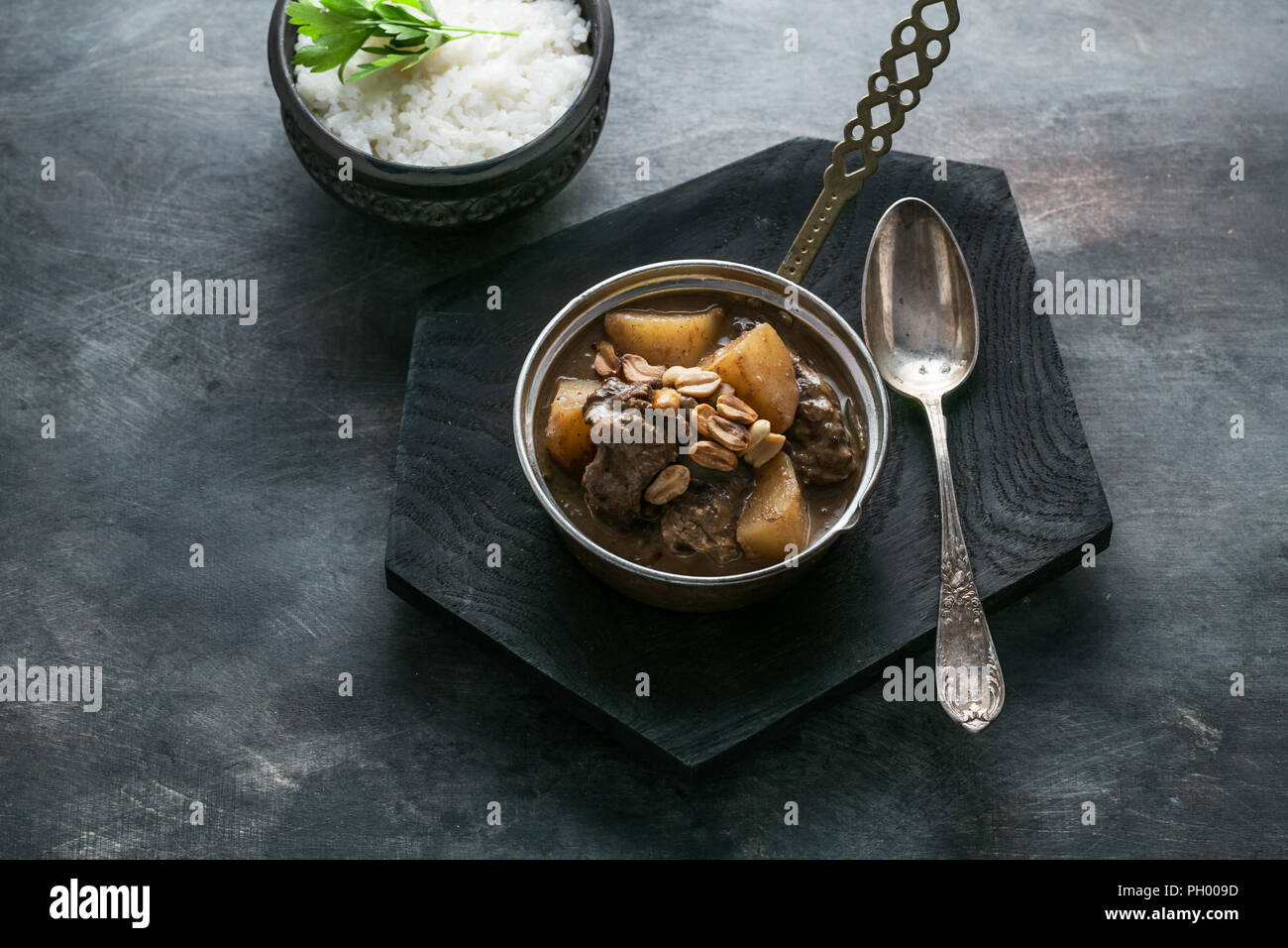 Thai Beef Massaman Curry with Rice, dark background copy space Stock Photo