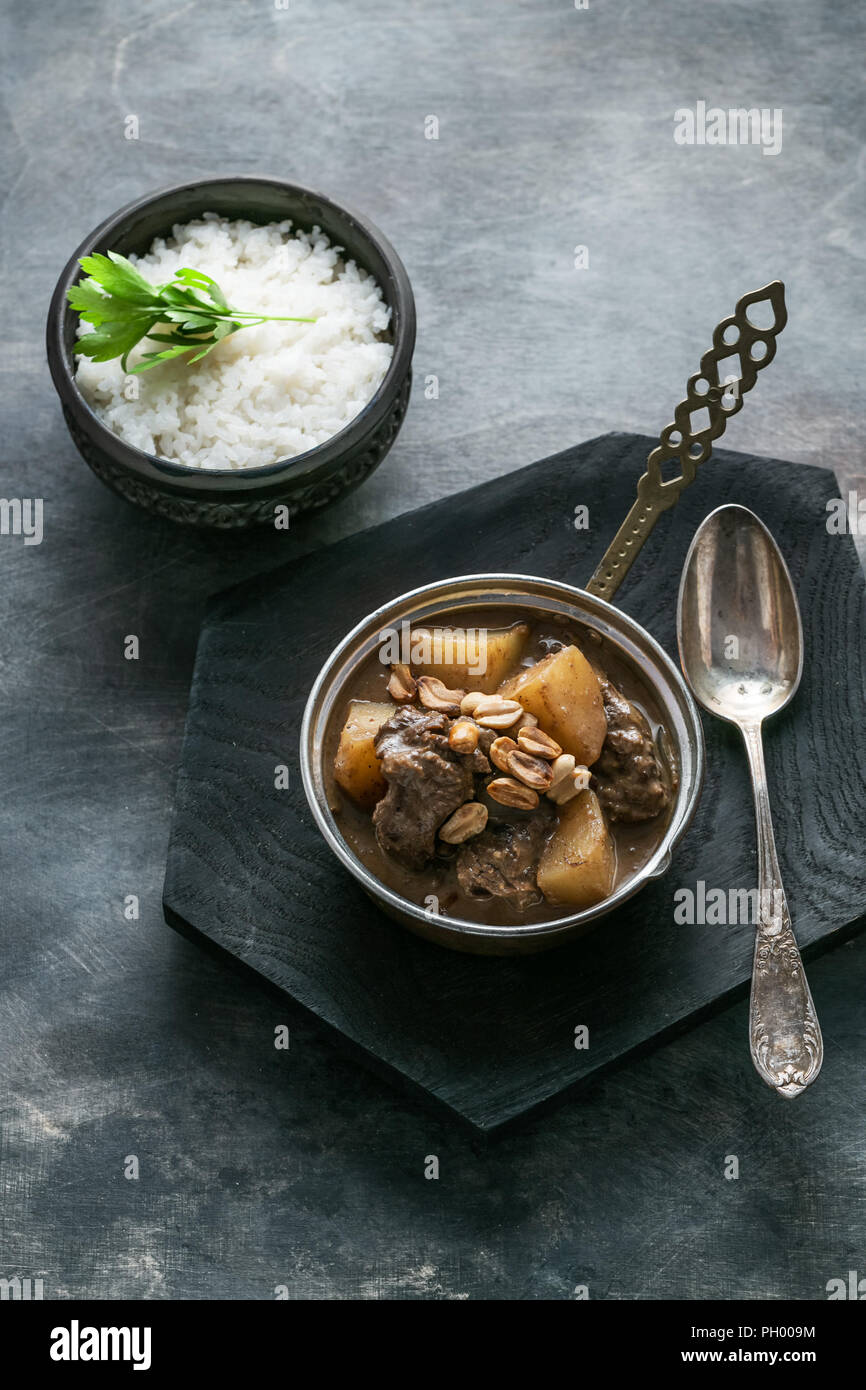 Thai Beef Massaman Curry with Rice, dark background copy space Stock Photo