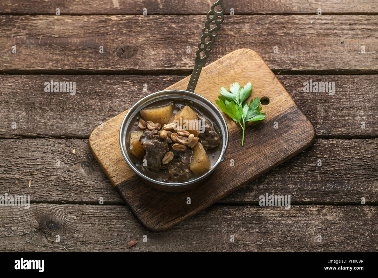 Portion of massaman curry in copper pan, top view, rustic style Stock Photo