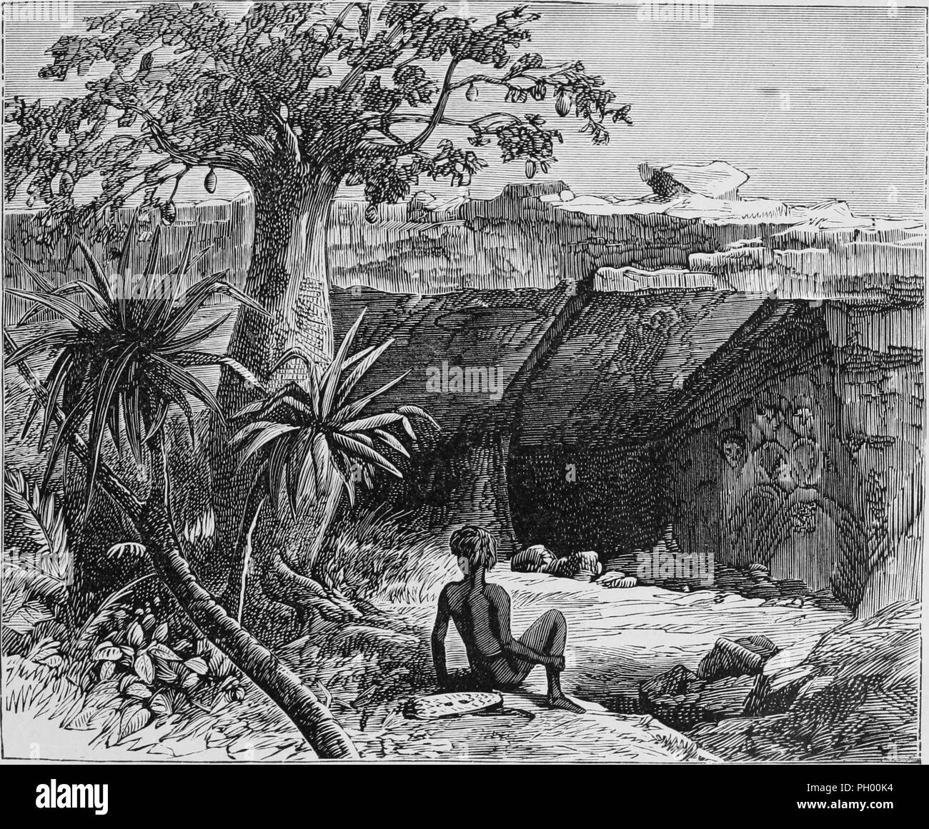 Black and white vintage print, depicting an Aboriginal Australian, seated at the edge of a cliff overlooking the entrance to a cave, with drawings of people and kangaroos visible on the cave walls in the background, located in Australia, published in John George Wood's volume 'The uncivilized races of men in all countries of the world, being a comprehensive account of their manners and customs, and of their physical, social, mental, moral and religious characteristics', 1877. Courtesy Internet Archive. () Stock Photo
