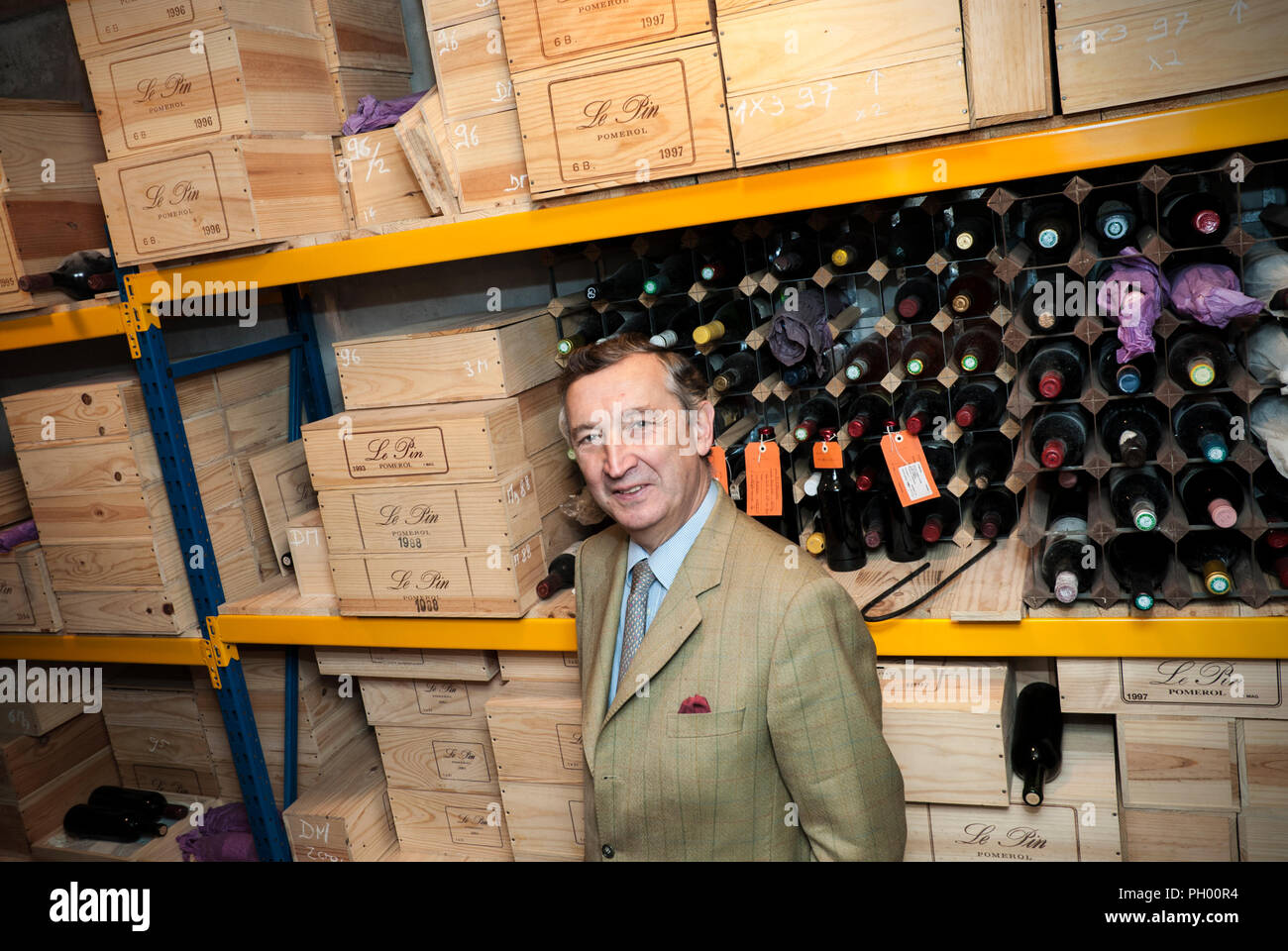 Jacques Thienpont in his Château Le Pin wine cellar with cases and bottles of renowned ‘Le Pin’ Bordeaux fine wine from appellation Pomerol France Stock Photo