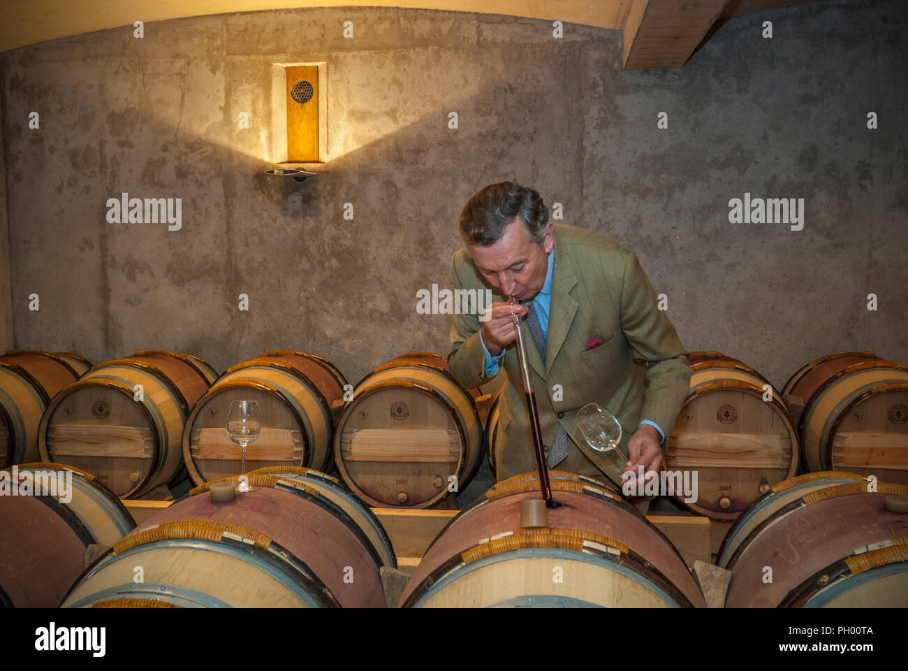 Jacques Thienpont in his Château Le Pin wine barrel cellar, drawing a tasting glass from barrel of his renowned 'Chateau Le Pin’ Bordeaux fine wine appellation Pomerol France Stock Photo