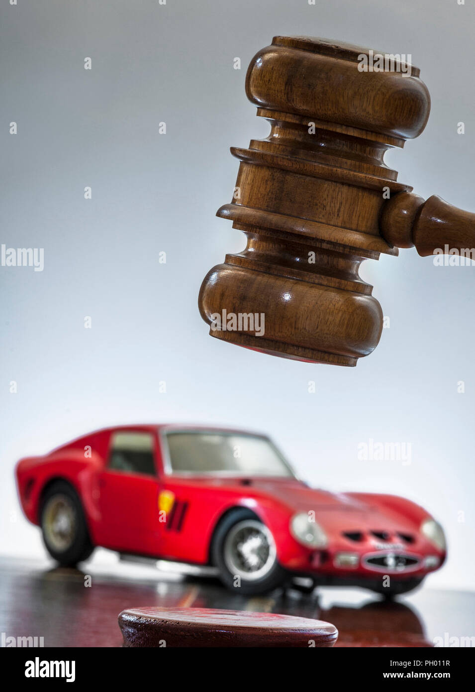 Auction Car 1963 Ferrari 250 GTO with auctioneers hammer in sale-room Concept image of classic renowned red vintage Ferrari with auction hammer Stock Photo