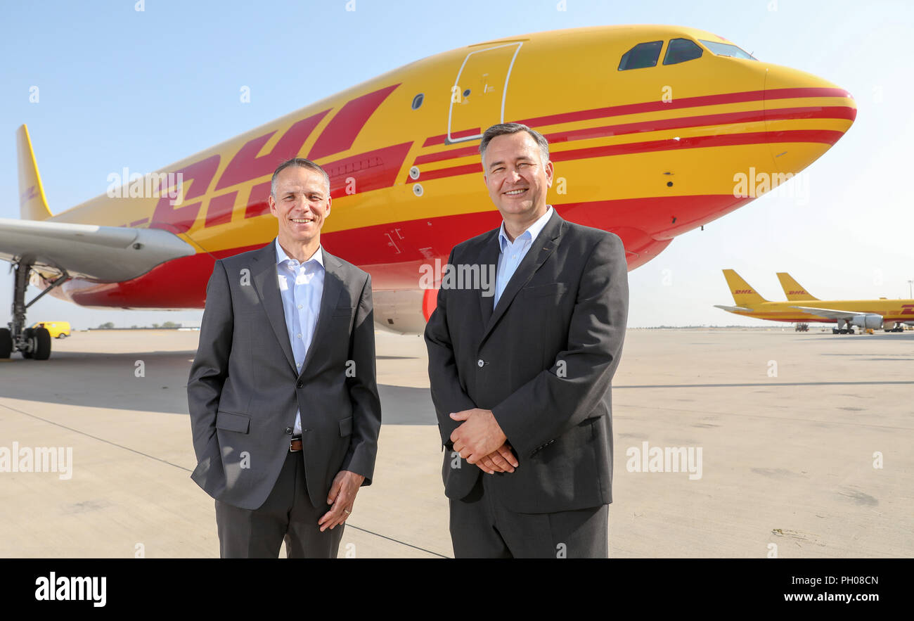 29 August 2018, Germany, Schkeuditz: Ralph Wondrak, CEO of DHL Hub Leipzig (l), and Markus Otto, CEO of European Air Transport Leipzig GmbH, are standing in front of a DHL freighter (Airbus A330 200) at Leipzig/Halle Airport. Ten years ago, the logistics company moved its hub from Brussels to Leipzig. Since then, the volume of air freight has been growing. Almost 1.14 million tons of freight were handled in 2017, an increase of 8.2 percent over the previous year. Up to 65 machines for DHL alone are in operation at the airport on working days. Photo: Jan Woitas/dpa-Zentralbild/dpa Stock Photo