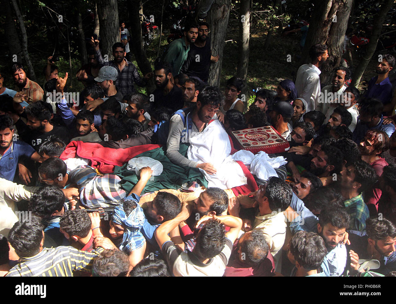 Kulgam, Jammu and Kashmir, India. 29th Aug, 2018. Brother of slain militant  commander Altaf Ahmad Dar is seen next to the dead body in Hawoora village  of south Kashmir's Kulgam some 70