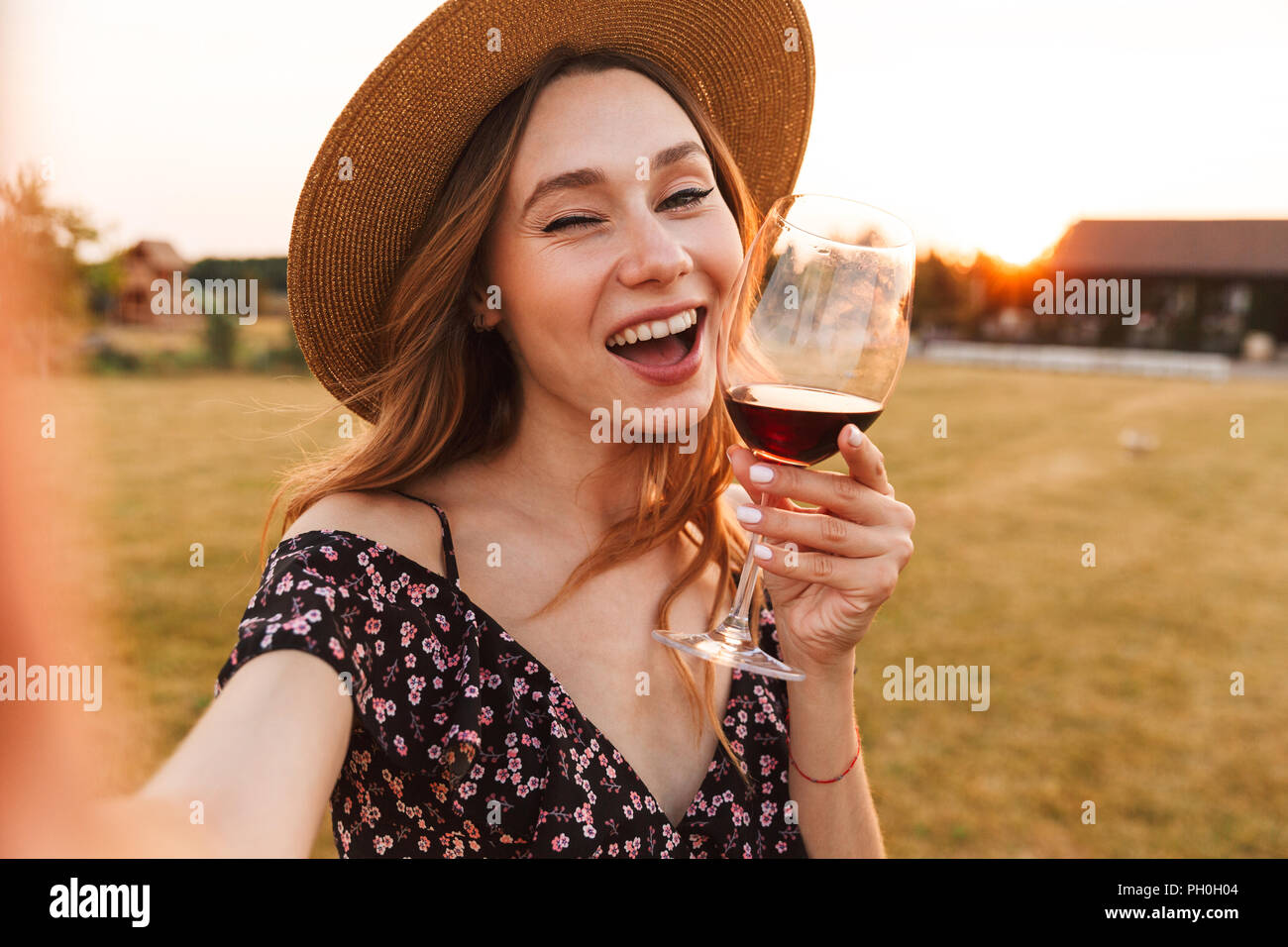 Image of cute pretty young woman outdoors holding glass drinking wine ...